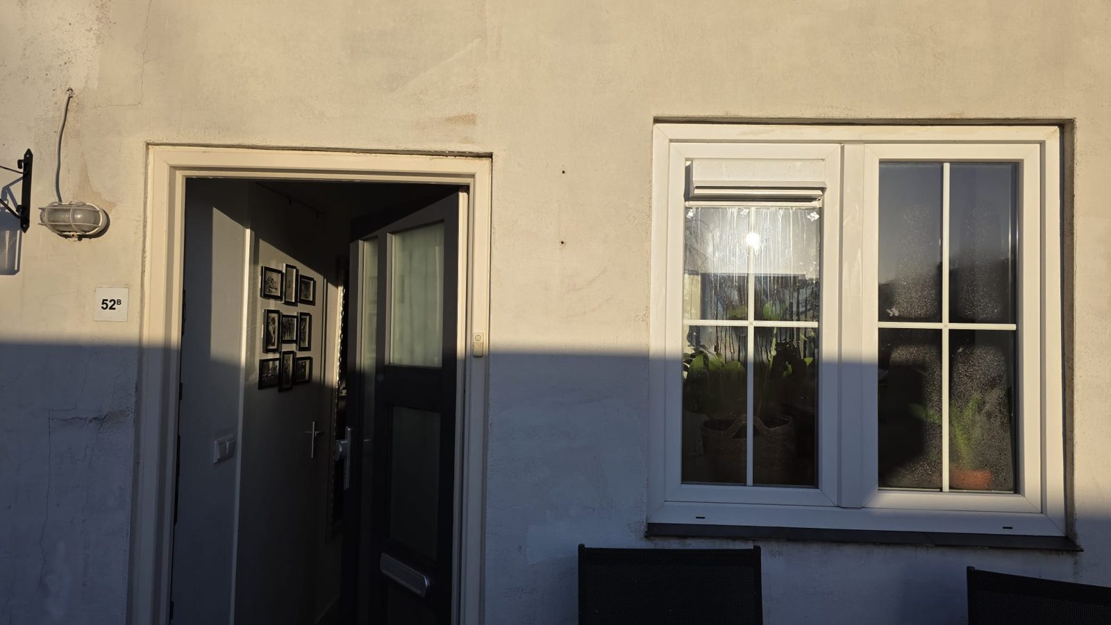 Antraciet voordeur en kozijn in warm avondlicht